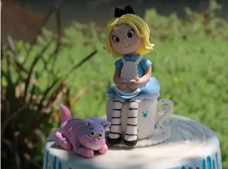 Menina sentada em uma xícara de chá ao lado de um gato